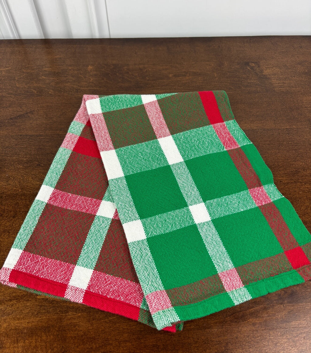 Green, red, and white plaid towel on a wooden surface