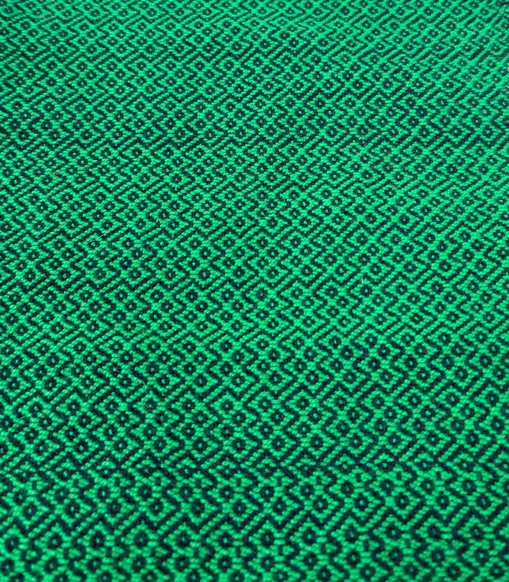 Green fabric texture with a geometric pattern