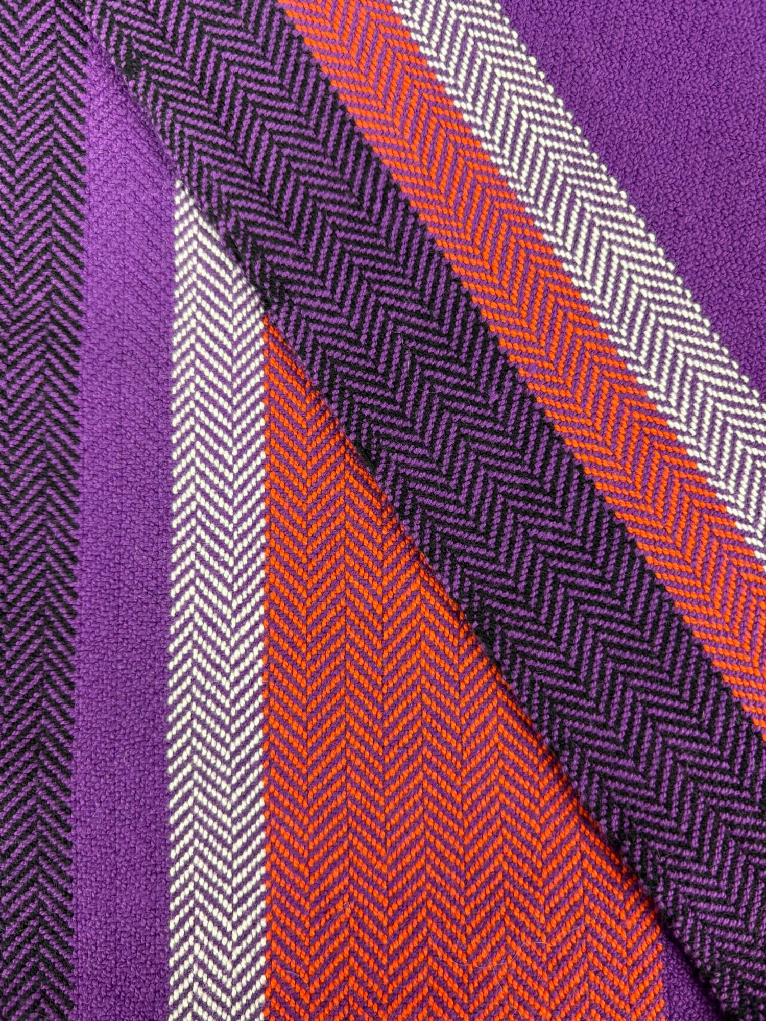 Close-up of Towel with purple, orange, and white herringbone pattern