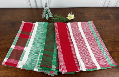 Set of red, green, and multicolored checkered towels on a wooden surface.