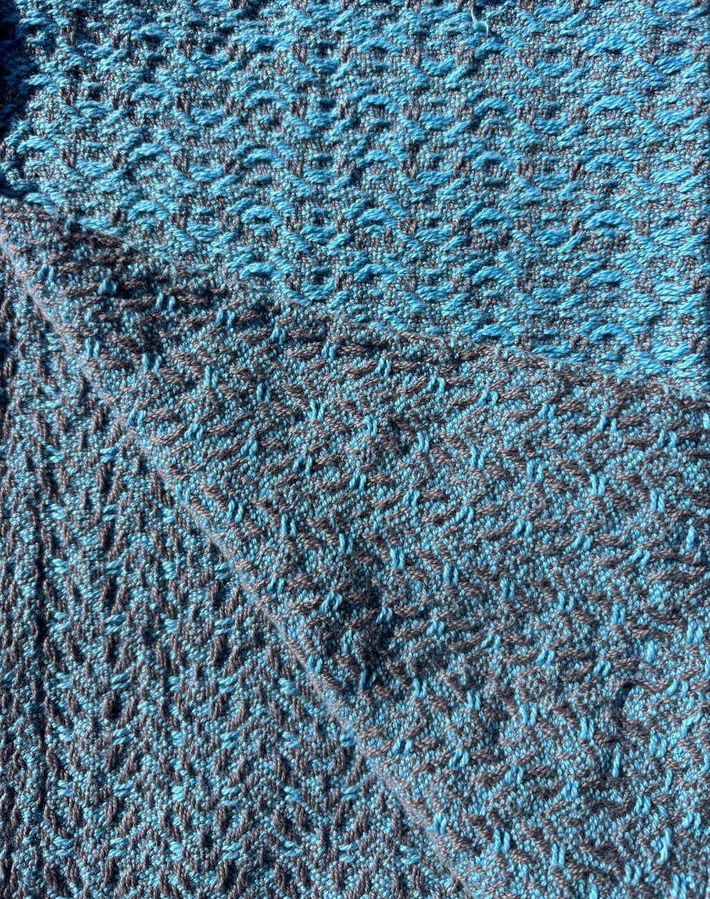 Towel woven with light blue yarn on grey in a brocade pattern