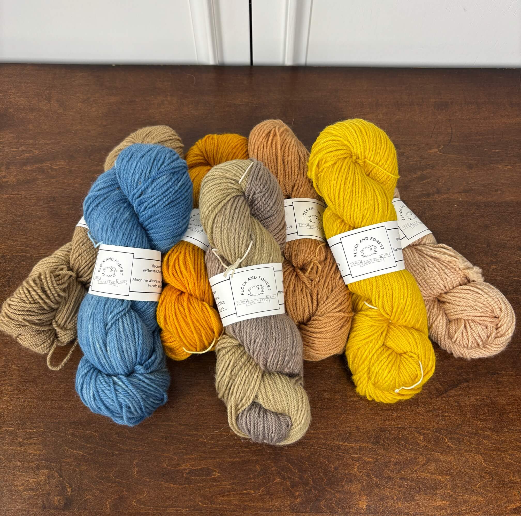 Set of colorful yarn skeins on a wooden surface