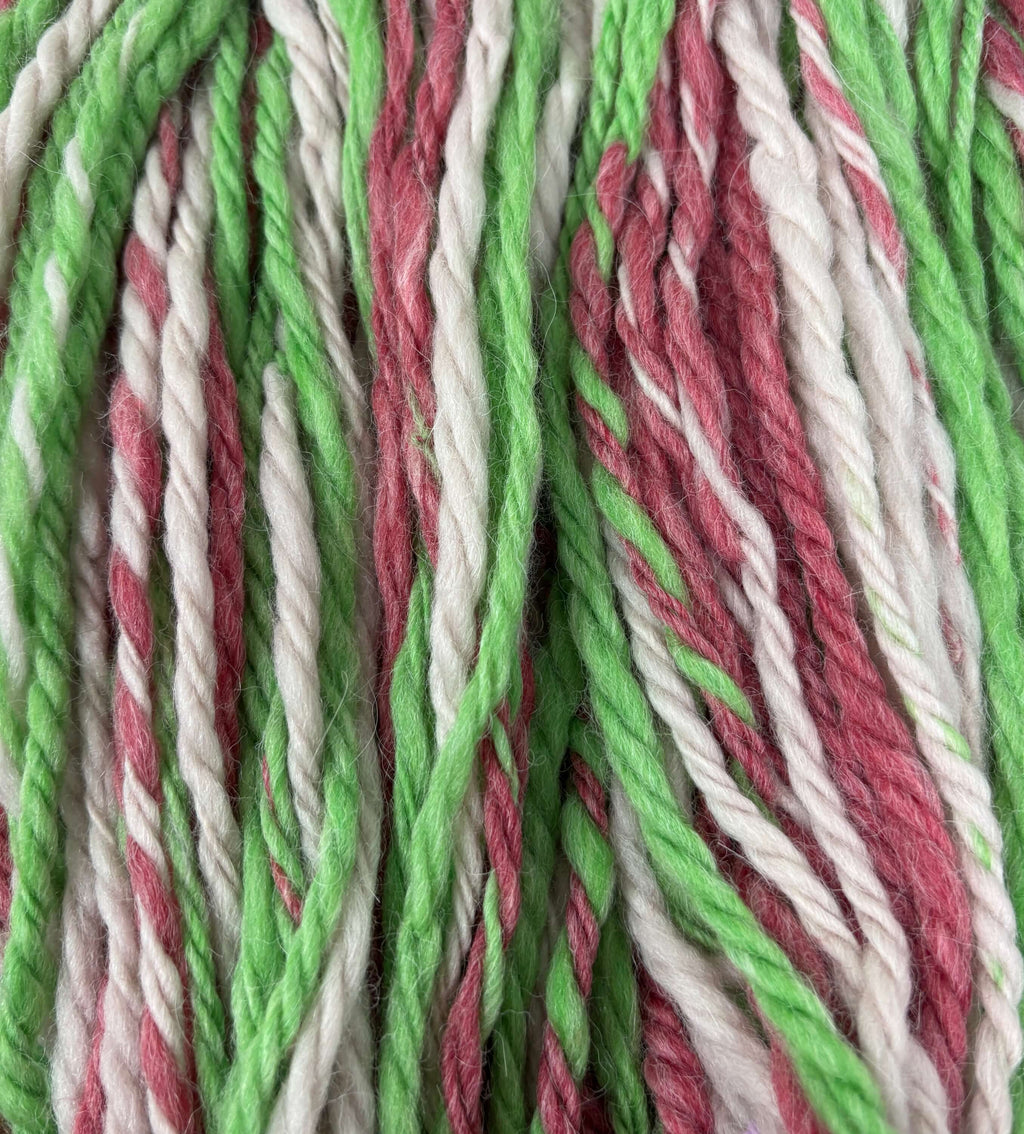 Close-up of green, red, and white chunky yarn strands.