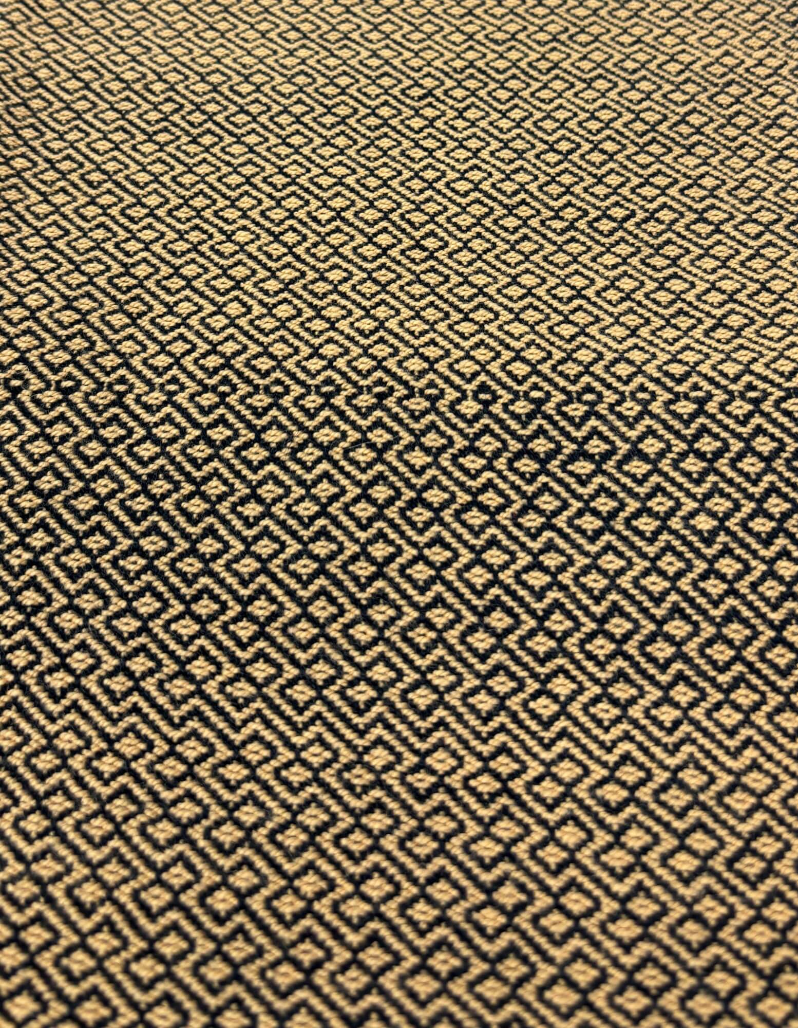 Patterned fabric with a geometric design in black and beige.