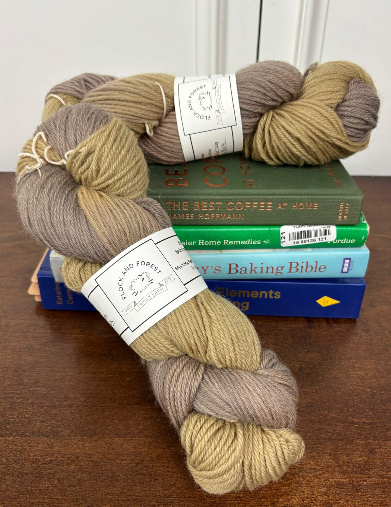 Brown and beige skeins of yarn on top of cookbooks with visible labels.